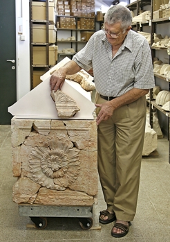 פרופ' נצר בוחן את ארון הקבורה המשוחזר של הורדוס (צילום: גבי לרון, המכון לארכיאולוגיה)
